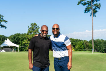 Torry Holt and Terrence Holt stand on a golf course 